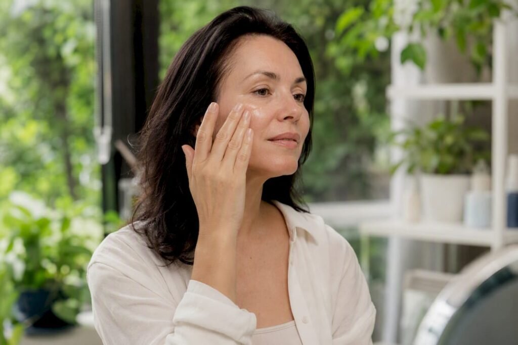 Woman applying antioxidant serum to cheek