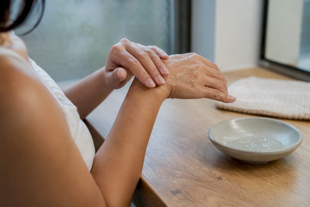 Hands massaging peeling gel on skin
