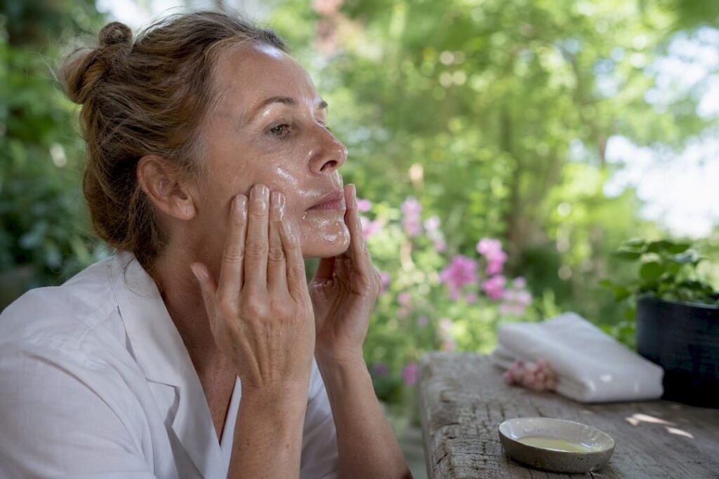 Mature woman massaging oil cleanser on face