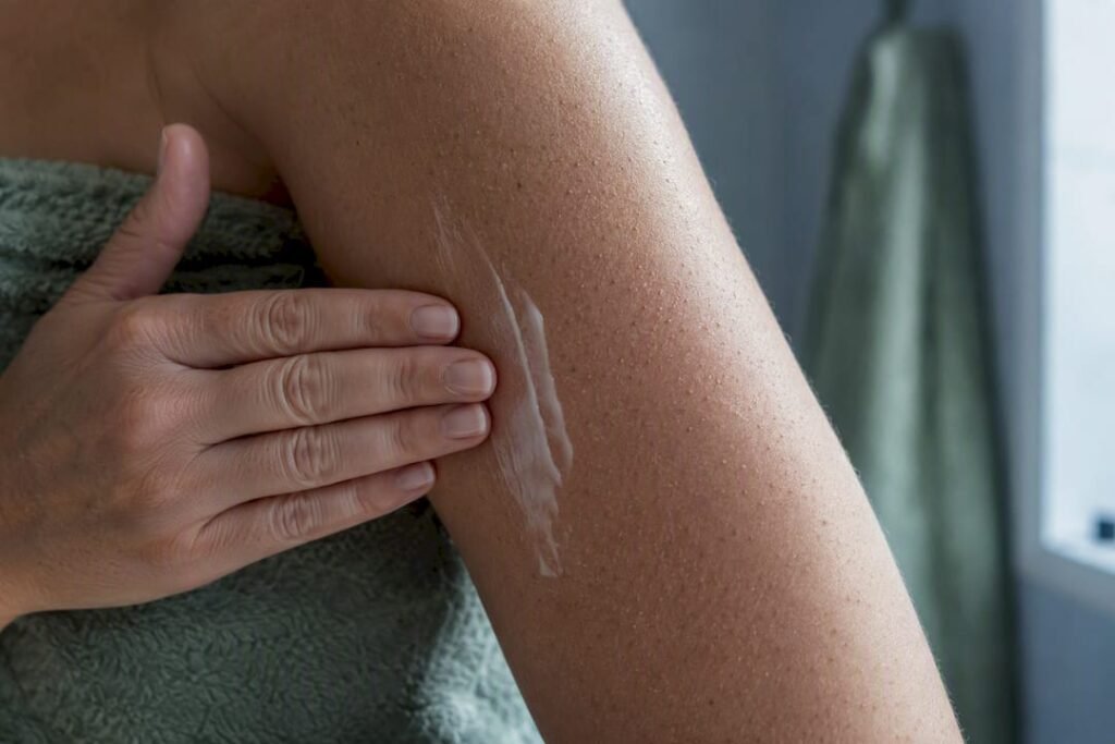Woman moisturizing textured upper arm